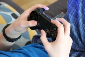 Close up of hands holding a video game controller.