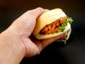 A hand holds a fast food sandwich.