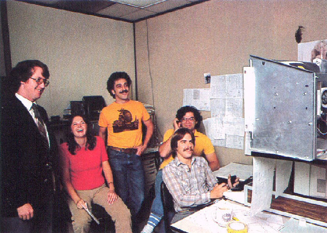 A group of men, and one woman--a younger Dona Bailey--in a studio setting.