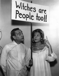 The witch Samantha from Bewitched holds a sign that reads Witches Are People Too