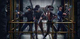 Promotional image of “Alien: Descent.” It shows four people wearing VR gear (visor headset, plastic gun, lightweight devices on their arms and legs) on a yellow metal lift, with facehugger aliens crawling around.
