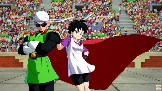 Image of Videl and the Great Saiyaman (a.k.a. Gohan) from “Dragon Ball FighterZ.” Videl is leaning against the Great Saiyaman. Videl is a young woman with short dark hair, wearing a white tank top over a purple shirt, black shorts, and fingerless gloves. The Great Saiyaman is a young man that looks like a superhero, with clothing like a red cape, green tunic, and dark sunglasses.